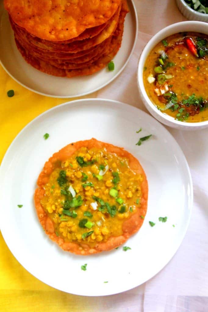 sindhi dal pakwan topped with onions, chutney, and cilantro