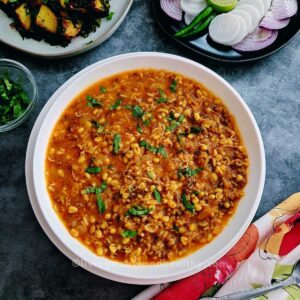 moong sprouts curry in a white serving bowl