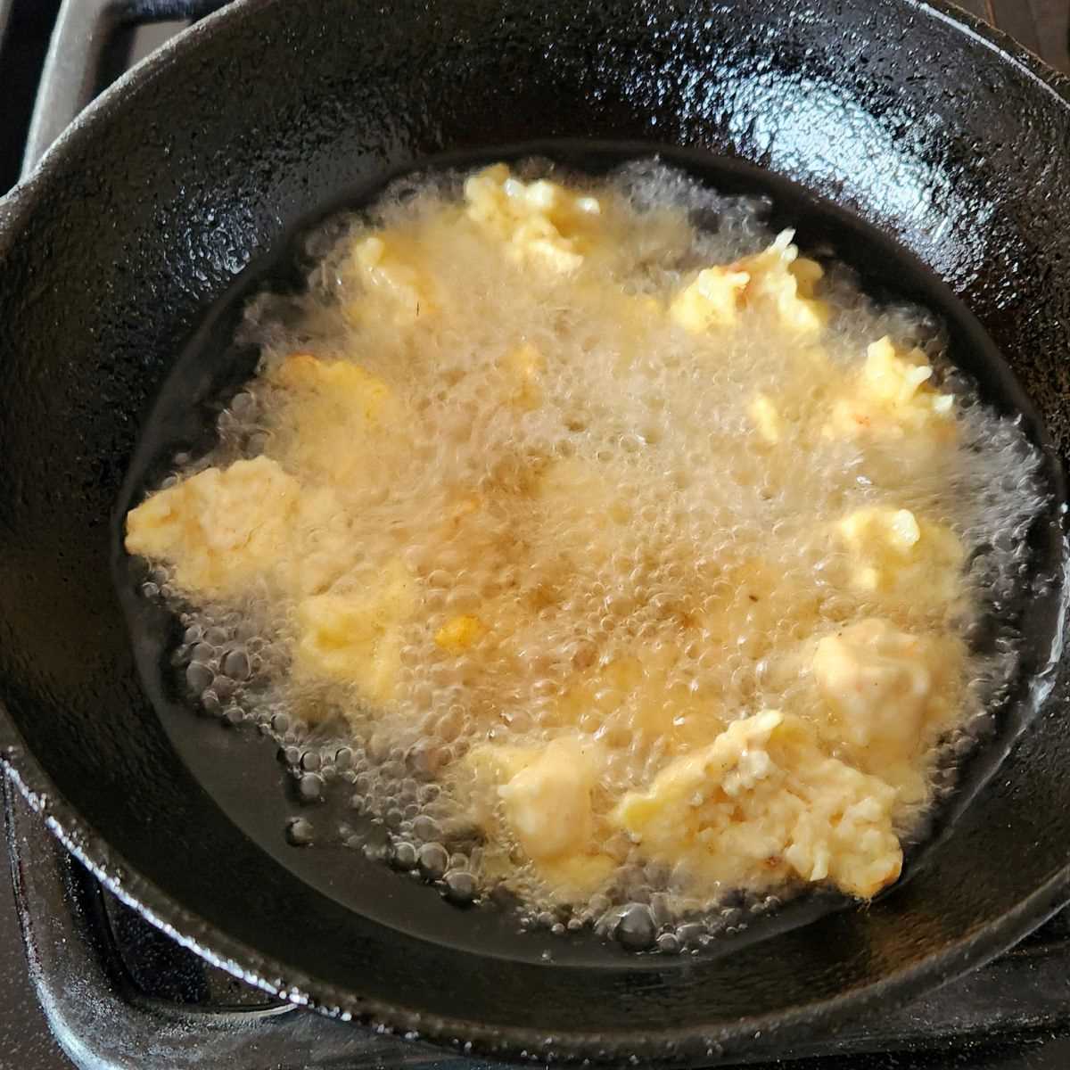 frying rice pakora in a wok