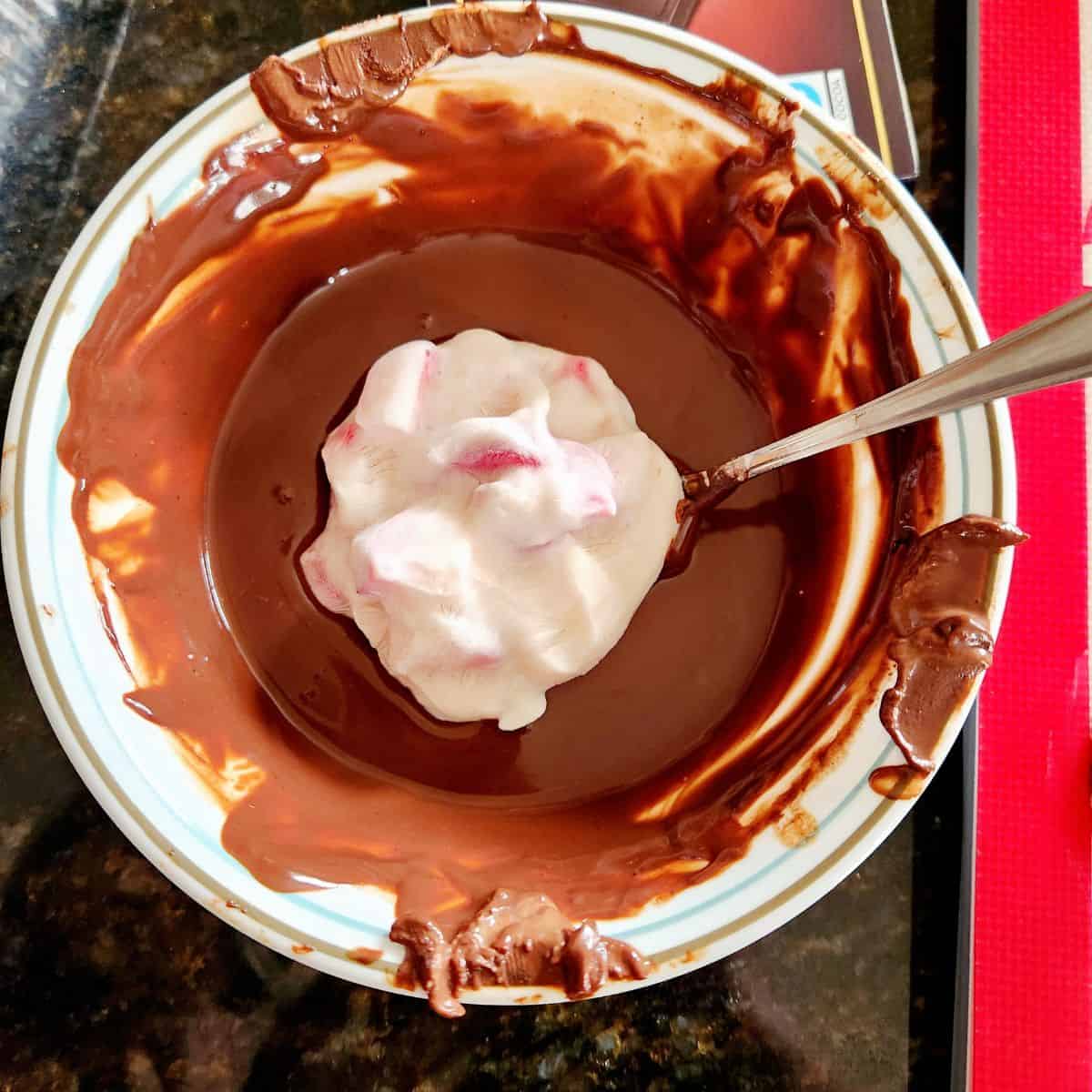 dip the strawberry yogurt cluster in the melted chocolate