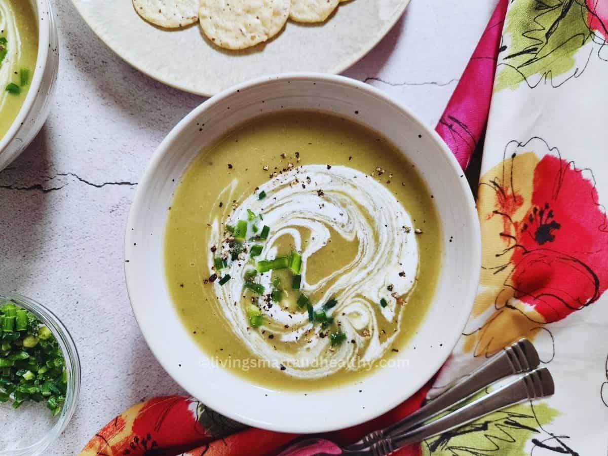 Low carb cream of celery soup with cauliflower and Greek yogurt in a white bowl