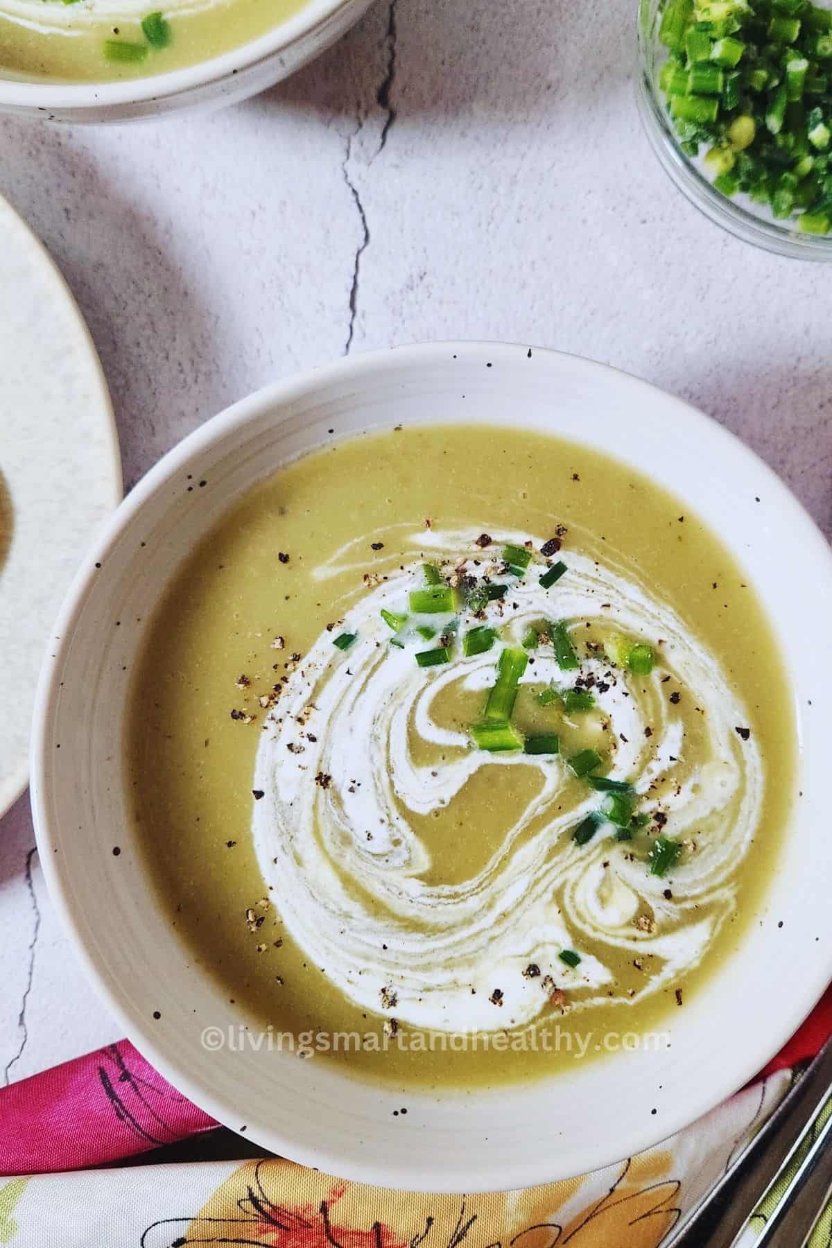 Healthy low carb celery soup served with cream, chives, and black pepper
