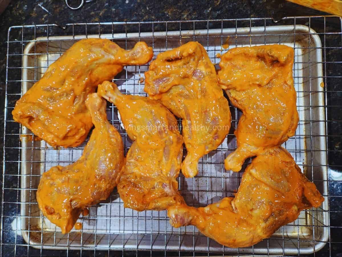 marinated chicken leg quarters in tandoori spices ready to be oven baked