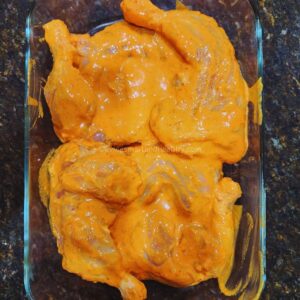 marinated tandoori chicken in a glass dish
