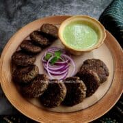 Serving mushroom galouti kebabs on a platter with mint yogurt sauce
