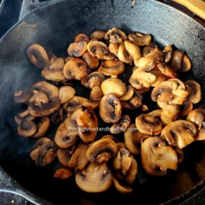 Sautéing sliced mushrooms in a cast iron skillet until golden and caramelized