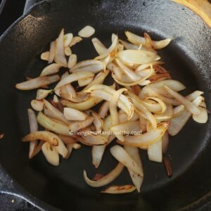 Caramelizing thinly sliced onions with garlic in ghee for rich flavor