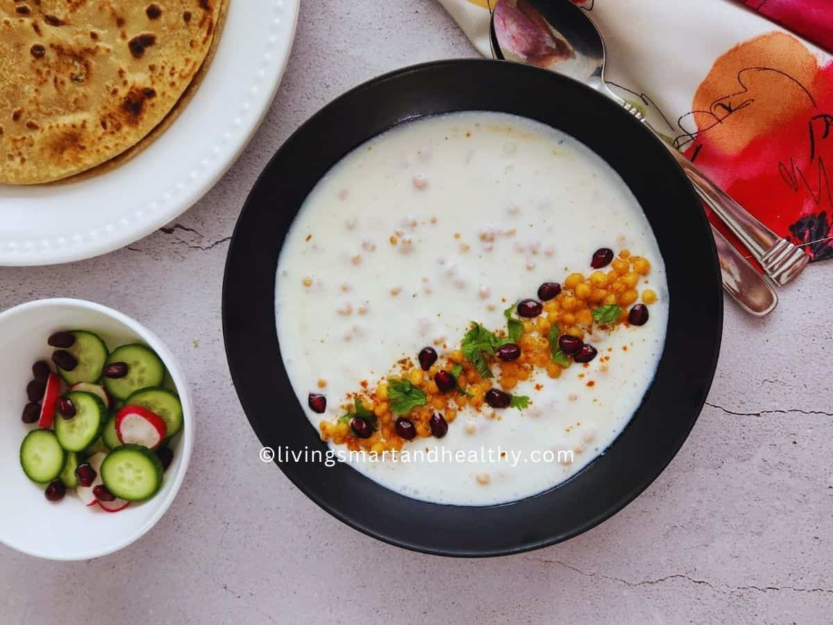 Boondi raita in a bowl garnished with cumin powder and coriander leaves