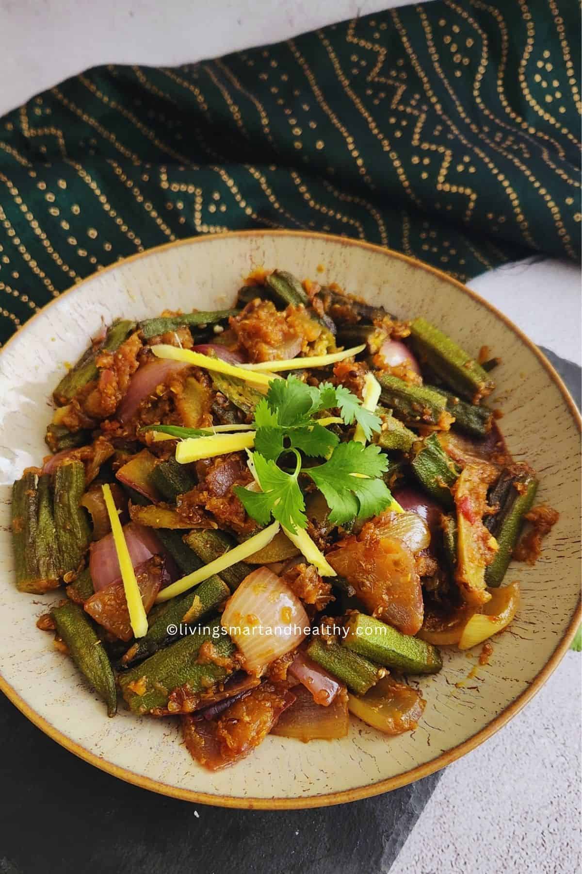 Close-up of Bhindi Do Pyaza showing charred okra edges and whole onion petals coated in spiced tomato masala