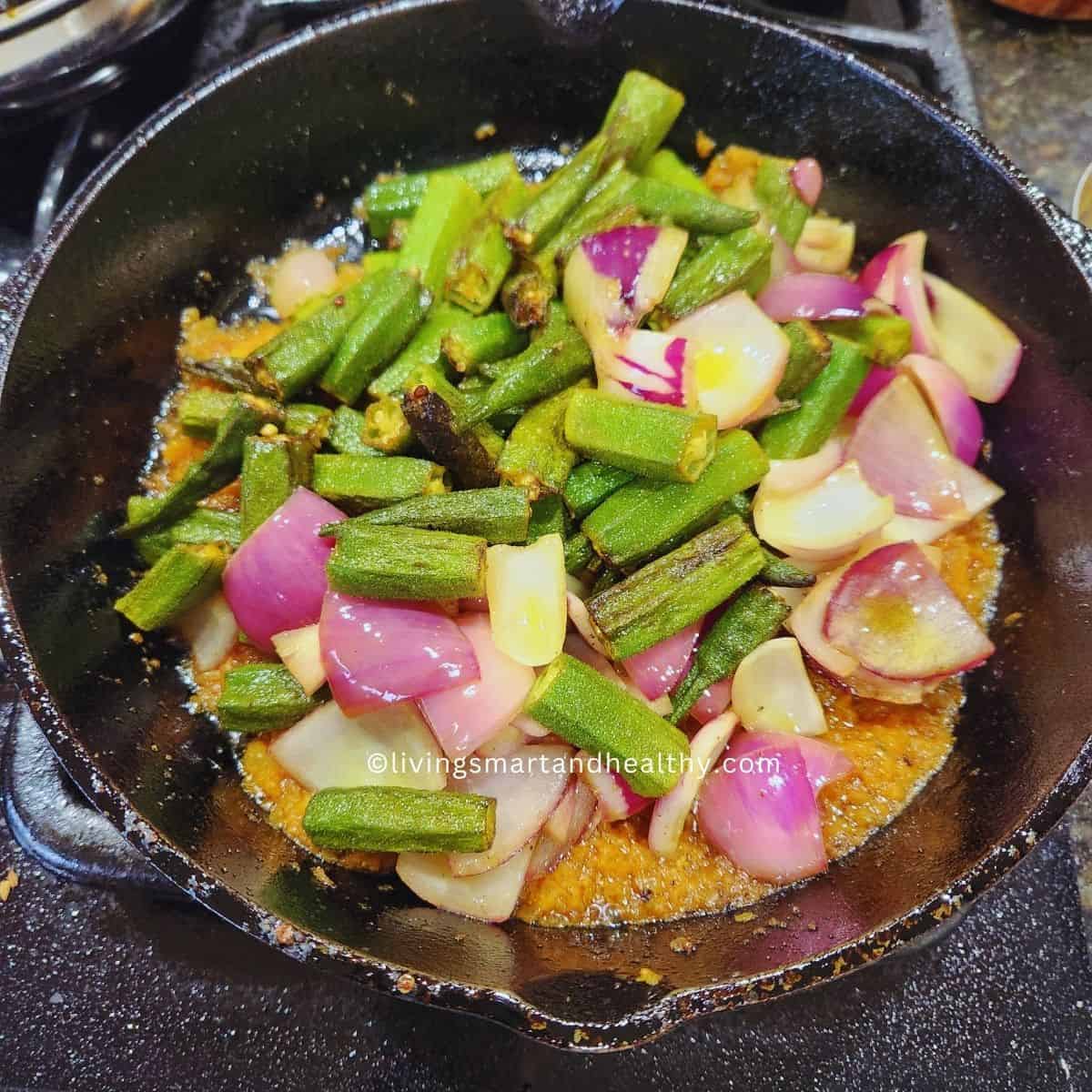 add par-cooked bhindi and onion petals to the masala