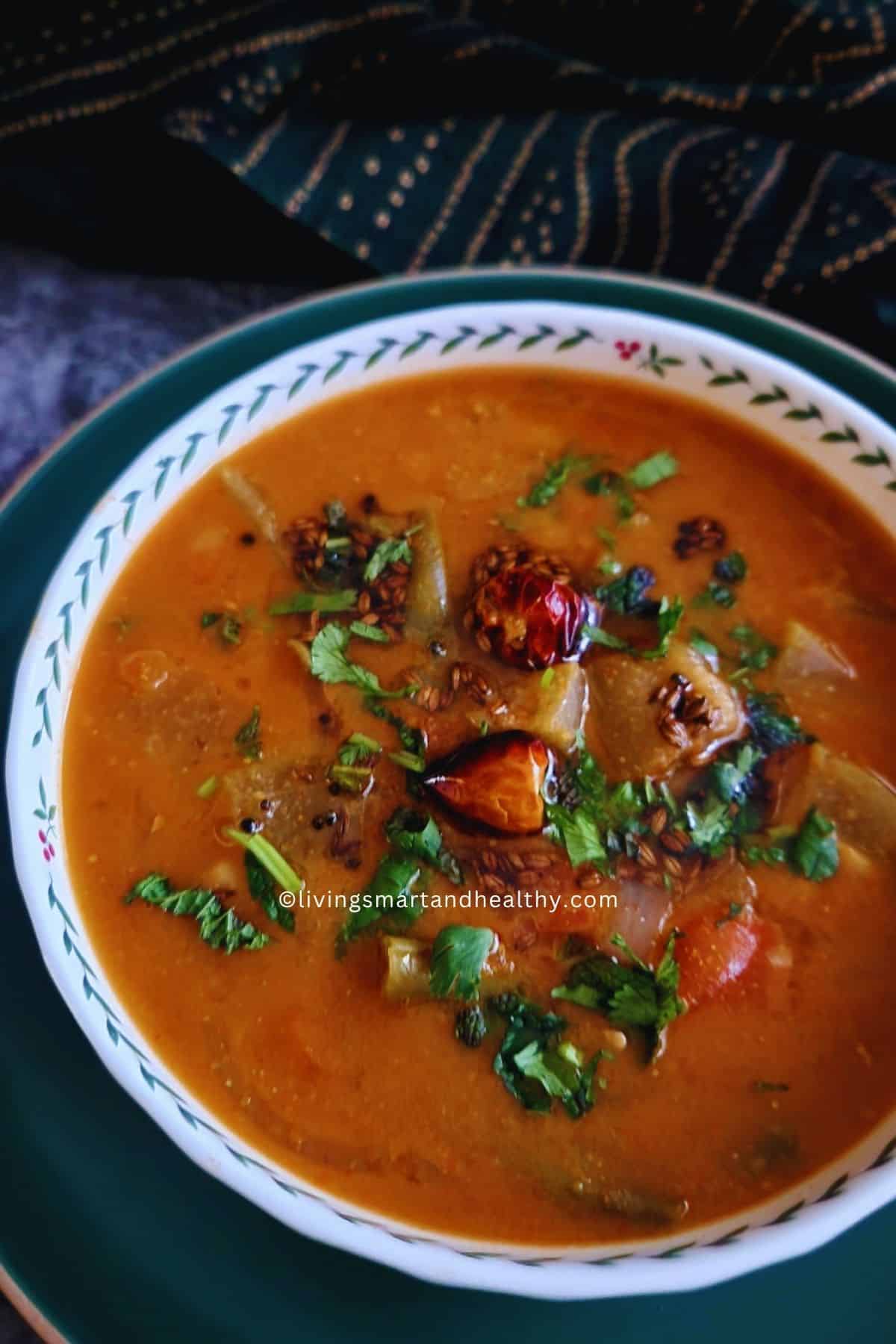 Pressure cooker sambar with toor dal and vegetables topped with mustard seed and curry leaf tempering