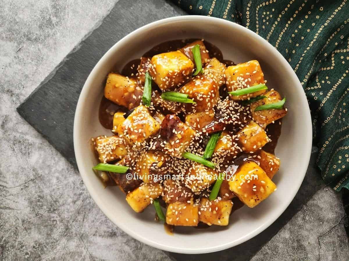 Golden crispy teriyaki tofu cubes glazed in sticky sauce, served over steamed rice and garnished with sesame seeds and green onions