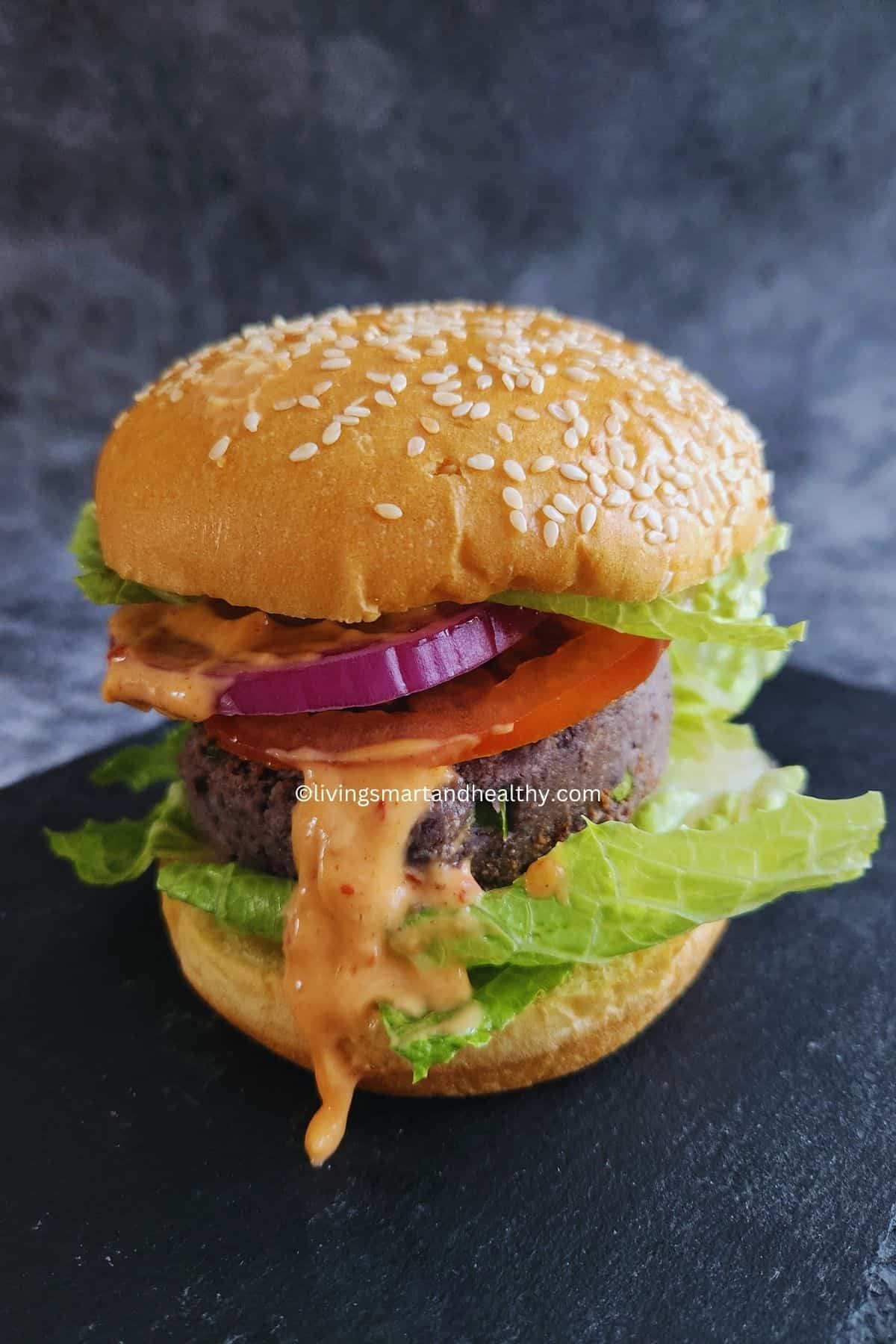 Black bean burger on a toasted bun with avocado, lettuce, and tomato