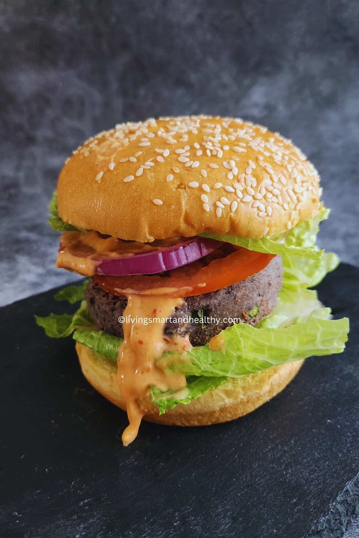 Black bean burger patties cooking in a cast iron skillet