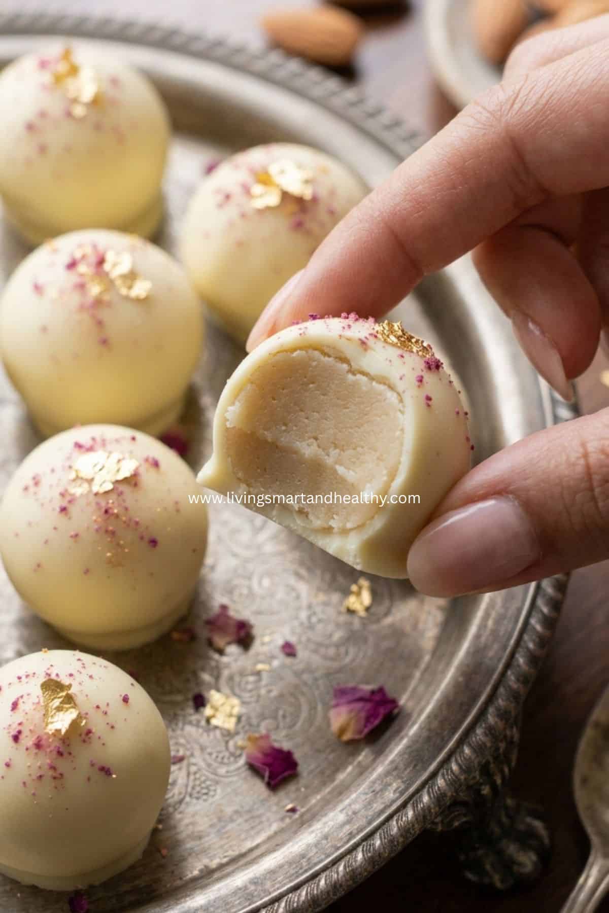 close-up of badam halwa truffles topped with crushed toasted almonds on a serving plate