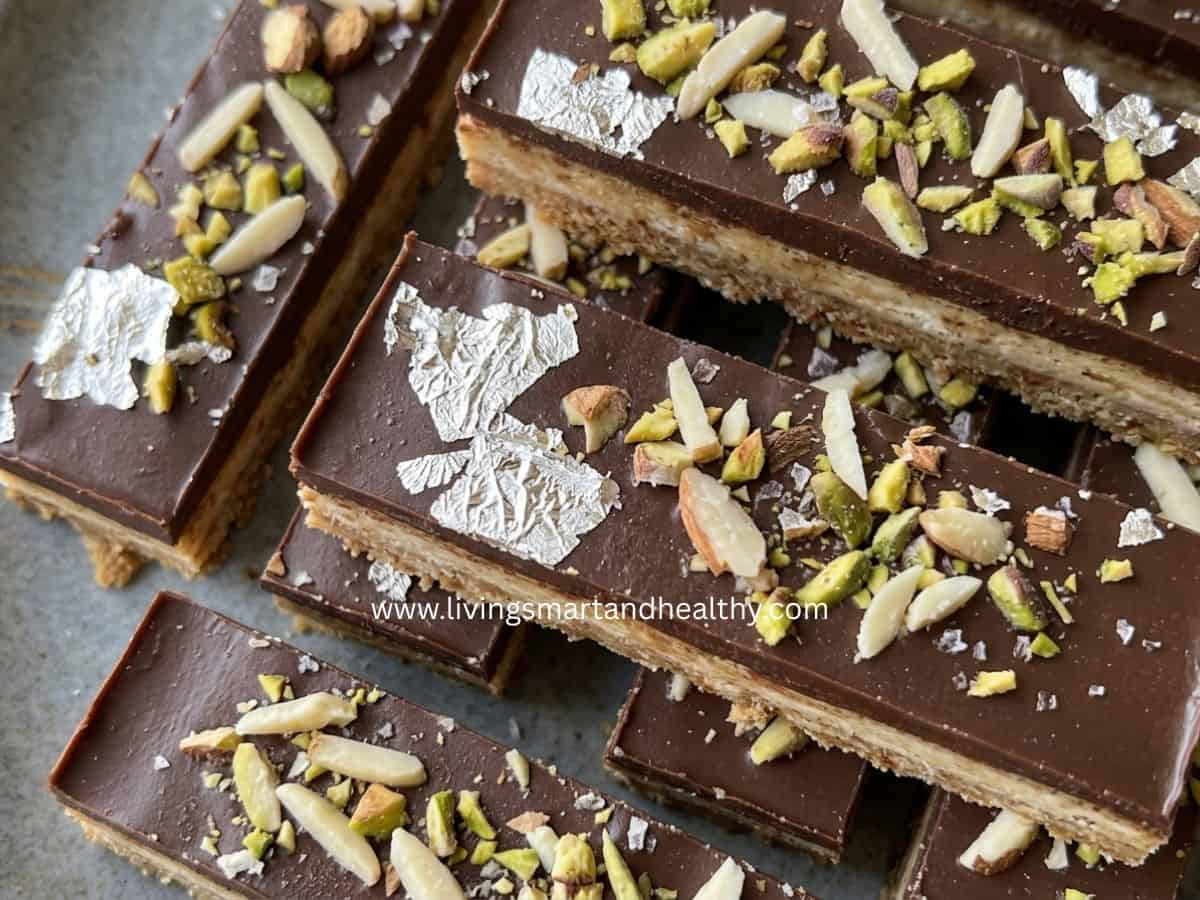 Layered Indian milk powder burfi bars garnished with pistachios.