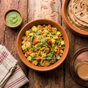 Tofu bhurji, an Indian-style tofu scramble, served in a pan with cilantro chutney and paratha