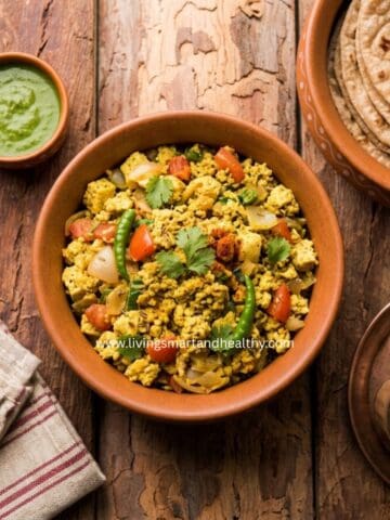 Tofu bhurji, an Indian-style tofu scramble, served in a pan with cilantro chutney and paratha